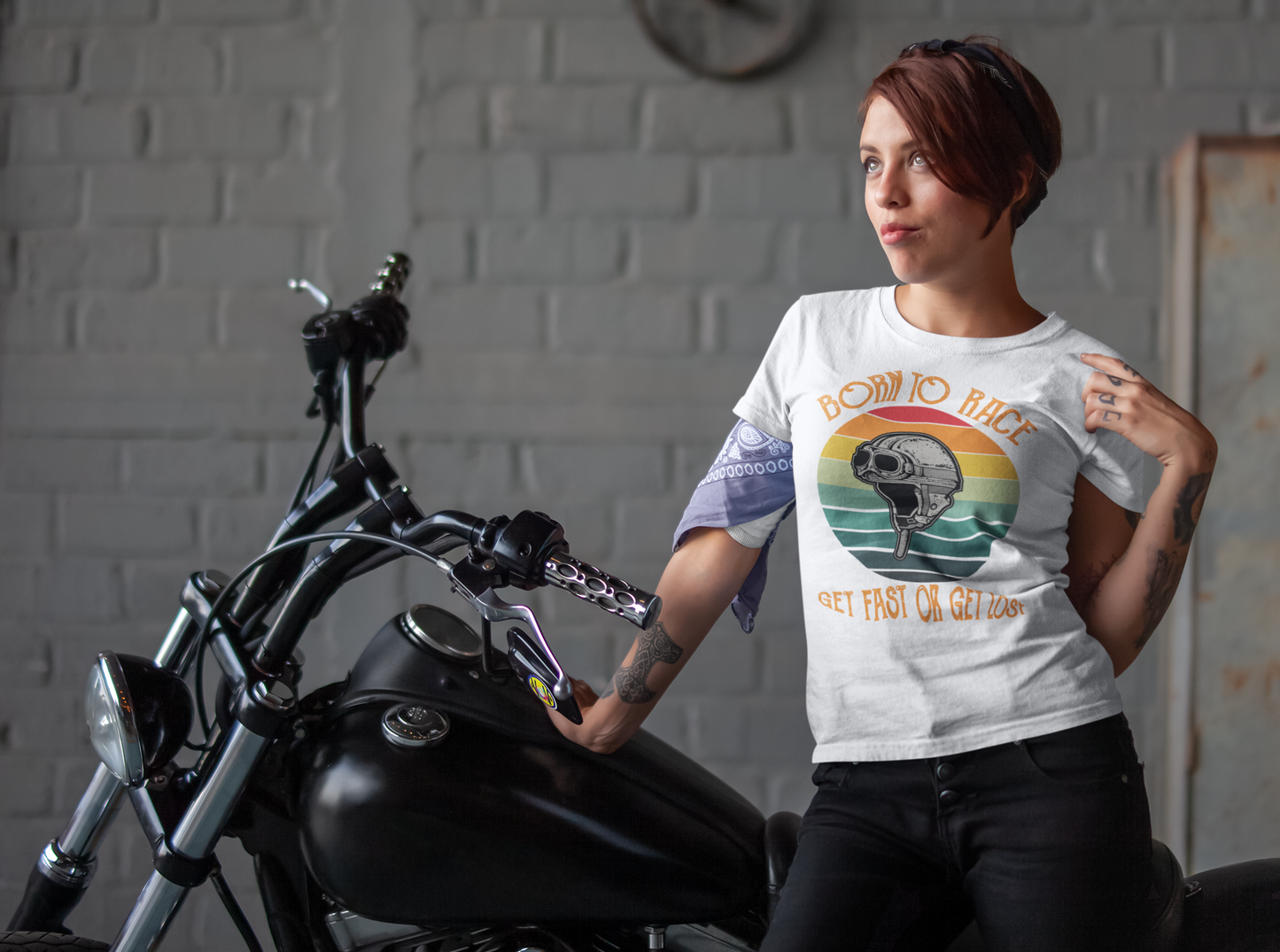 In this image its shows a biker chick styling her biker t-shirt with the wording "Born to race get fast or get lost"