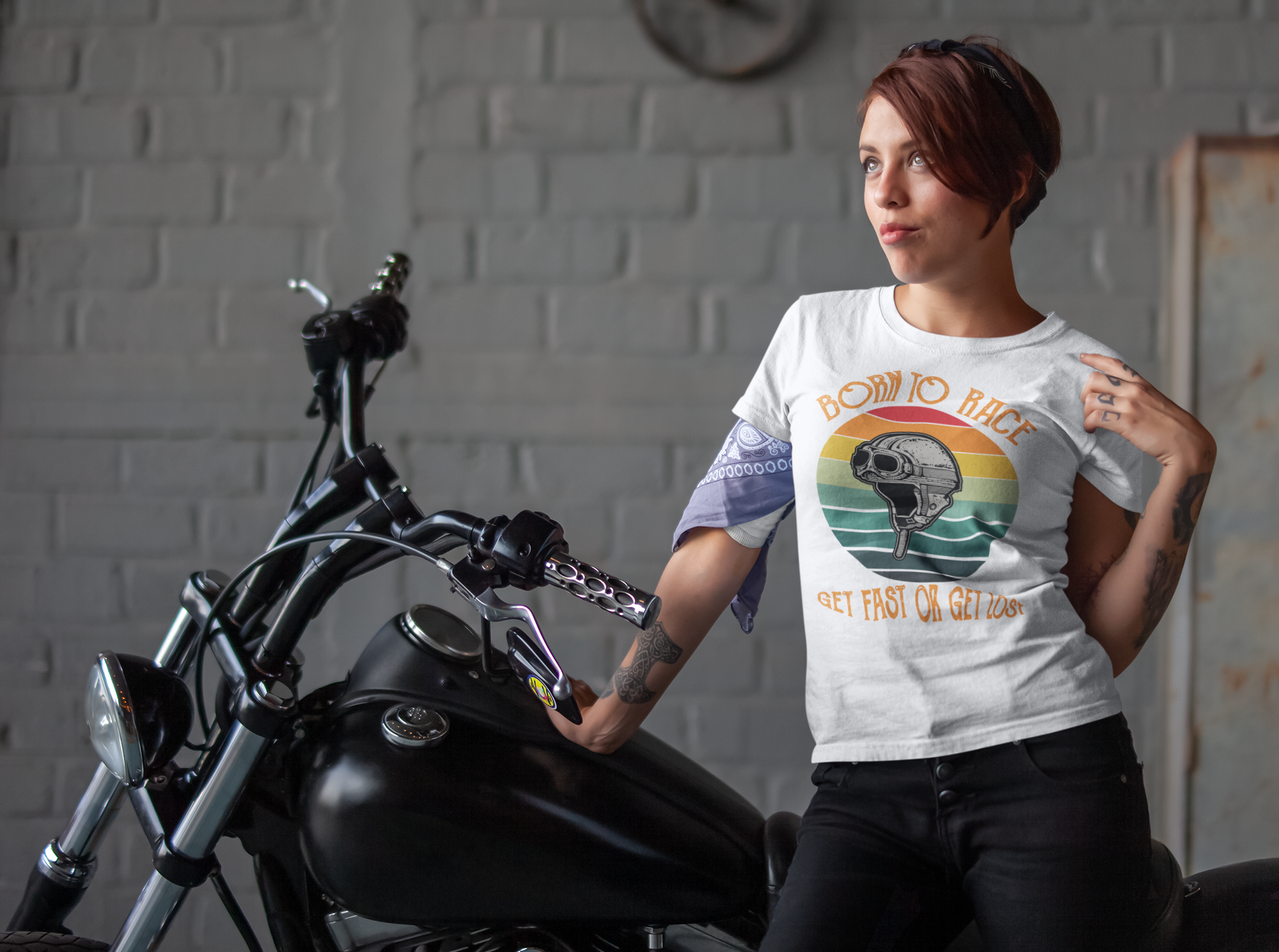 In this image its shows a biker chick styling her biker t-shirt with the wording "Born to race get fast or get lost"