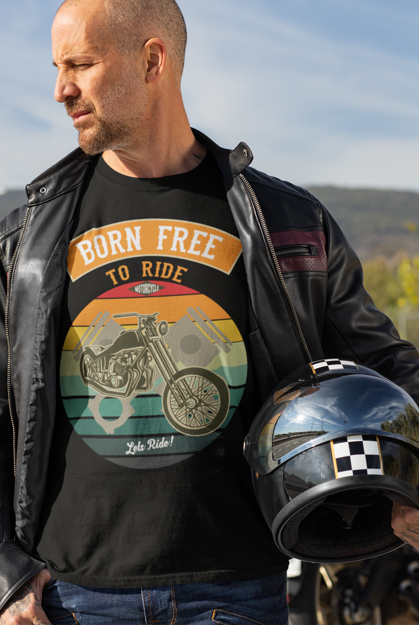 This Mock Up Of A Bikers tee Shows A Biker Holding His Helmet While Wearing The T-Shirt With The Lettering Of "Born Free To Ride"